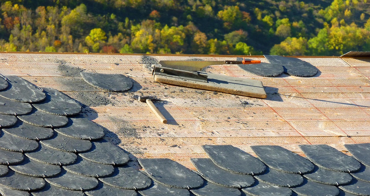 round asphalt roof shingles and hand tools on a roof