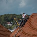 man working on a shingle roof