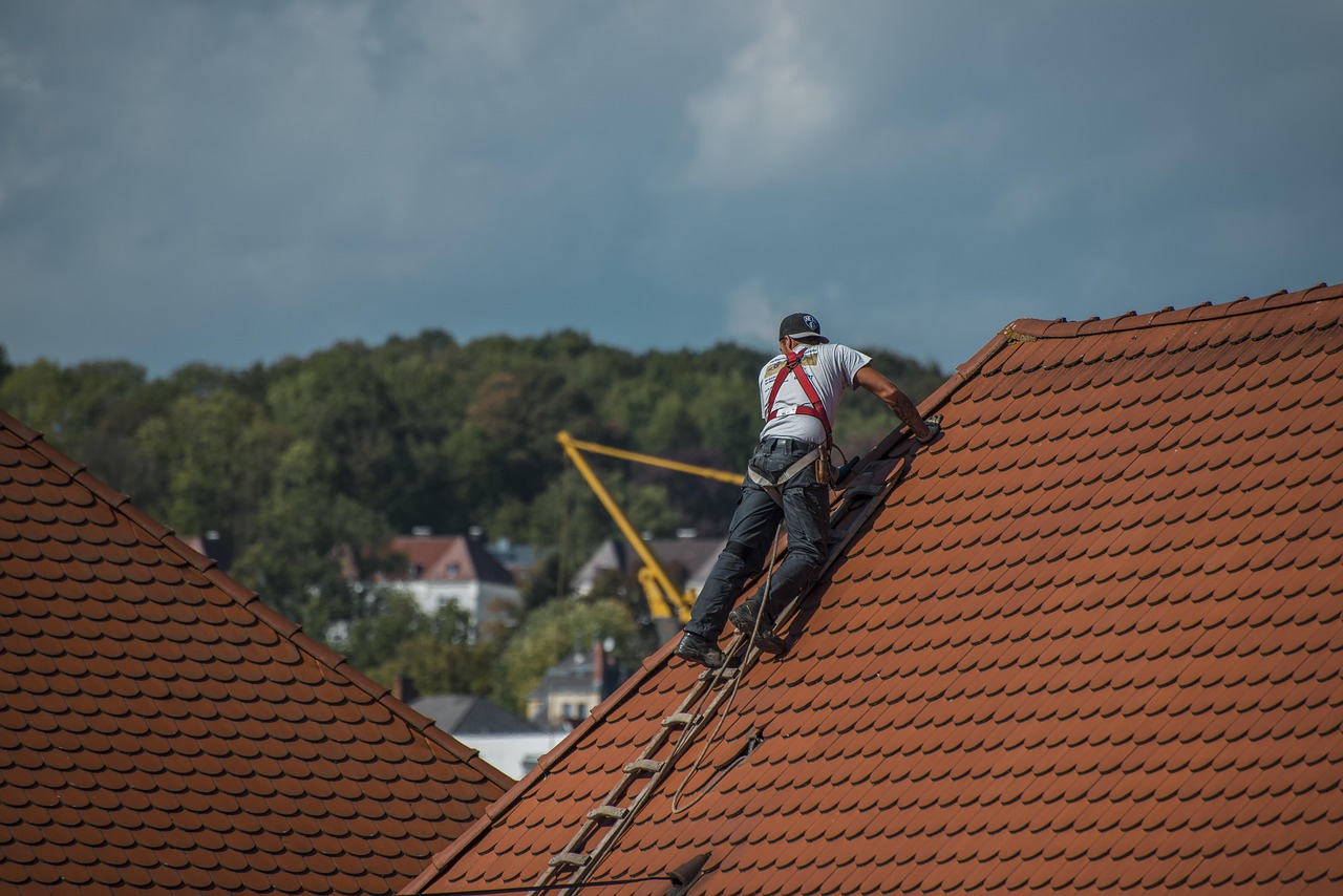 man working on a shingle roof