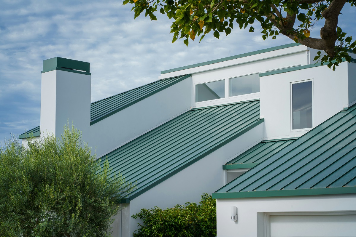 modern white house with a green metal roof